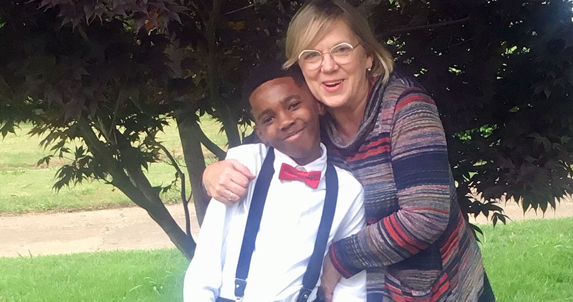 A kid dressed up well posing for a picture with an adult.